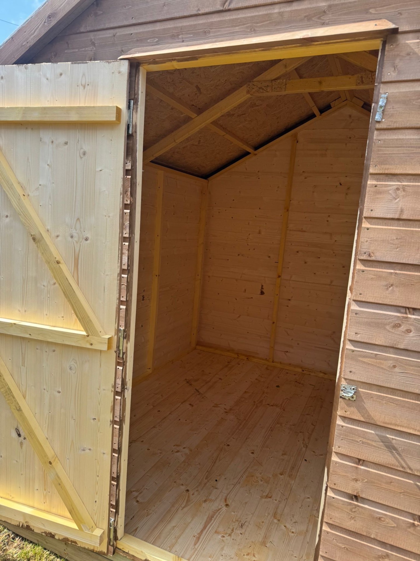 Interior of a timber shed showing tongue and groove lining and roof trusses