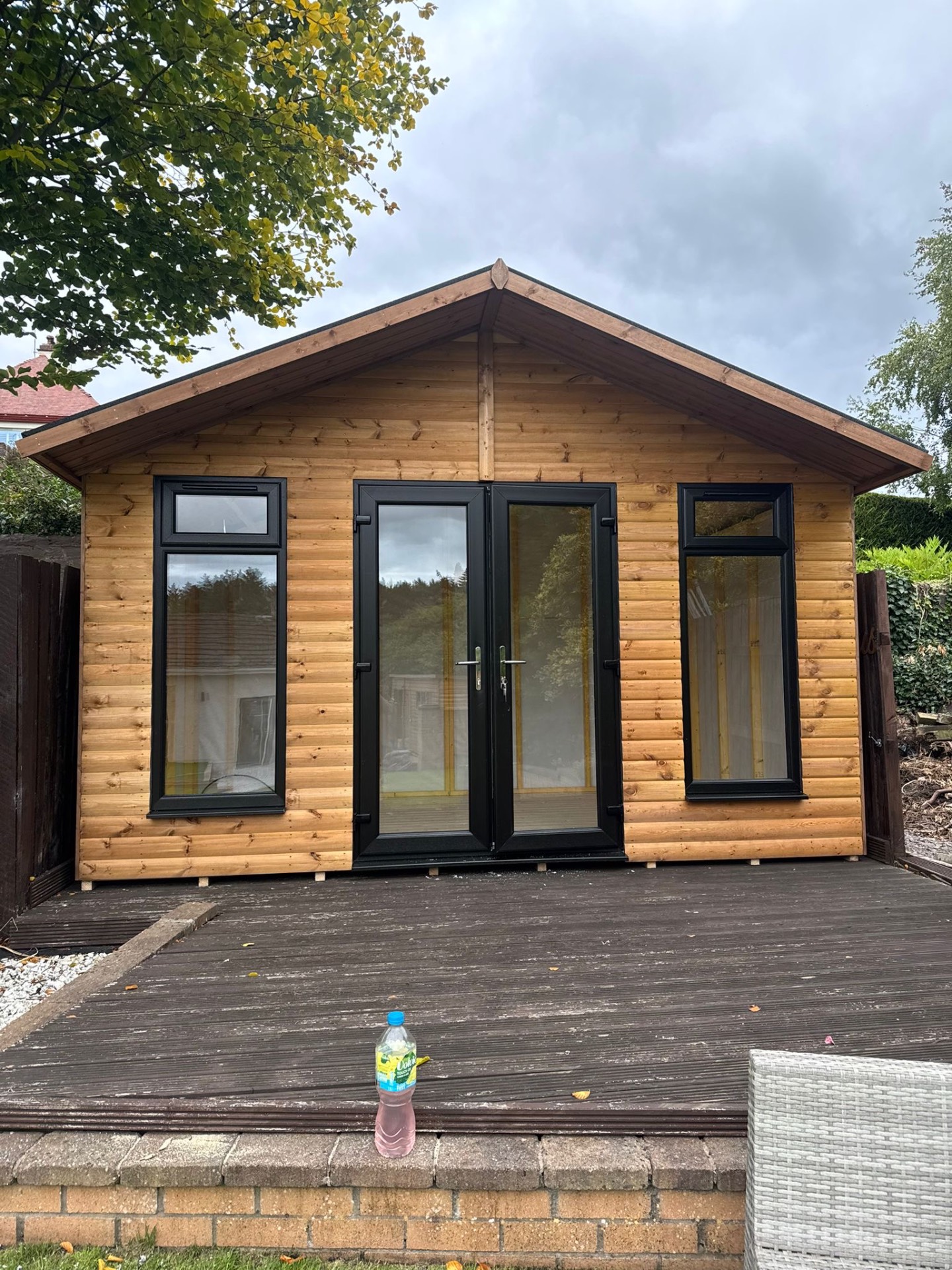 Front view of a timber summer house with anthracite windows
